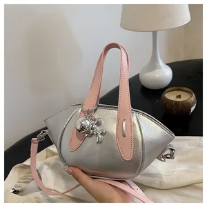 Close-up of metallic silver handbag with pink handles and balloon dog charm
