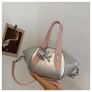 Detailed view of stylish silver metallic handbag with pink straps and a balloon dog charm