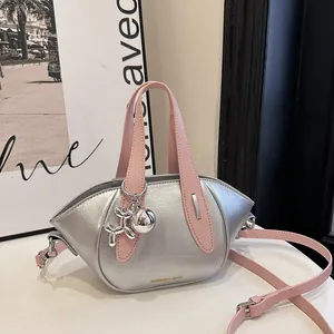 Sac seau élégant argenté et rose avec breloque chien ballon métallique et texture.