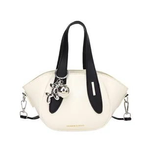 Sac à main seau tendance pour femme en crème et noir avec breloque chien ballon