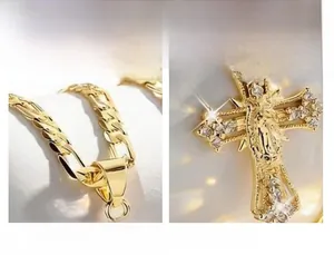 Close-up macro detail of religious gold cross pendant necklace with sparkling zircons.