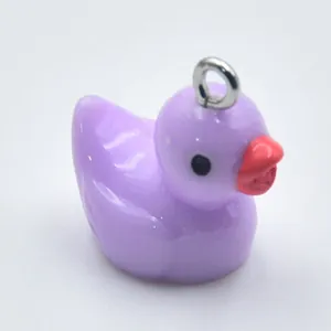 Detailed close-up view of a small purple resin cartoon duck charm for DIY jewelry making