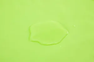 Macro-detail van waterdicht lindegroen PEVA-douchegordijnmateriaal met waterdruppels.