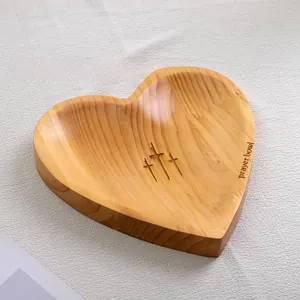 Heart-shaped wooden prayer bowl with engraved crosses and natural wood grain