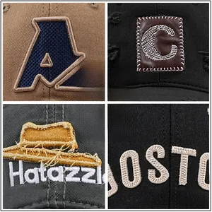 Detailed macro view of various embroidery and patch styles on cotton baseball caps.