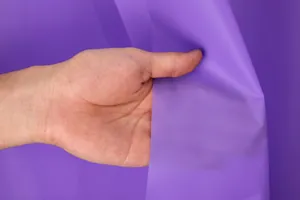 Detailweergave van de fijne textuur en paarse kleur van het waterdichte PEVA douchegordijn