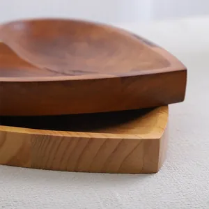 Close-up of stacked heart-shaped wooden bowls showing natural grain texture.