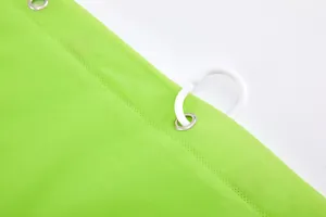 Detailopname van limoengroen PEVA douchegordijn met metalen ringen en witte plastic haak