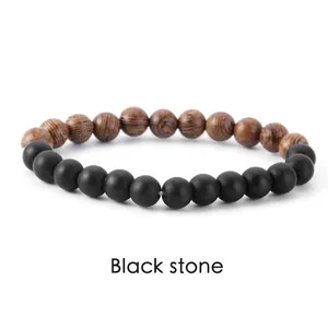 Detailed view of matte black stone and wood grain bead bracelet on white background