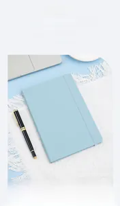 Gros plan d'un carnet A5 en similicuir bleu avec bande élastique et stylo-plume