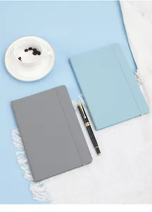 Professional A5 leather notebook with elastic closure on office desk setting.