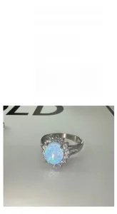 Gros plan d'une bague tournesol en acier inoxydable avec une pierre d'opale éclatante.