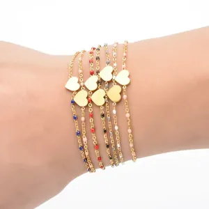 Set of gold stainless steel heart bracelets with colorful beads on a model's wrist