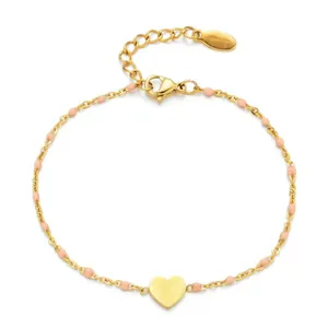 Close-up of gold stainless steel heart bracelet with pink enamel beads and chain.