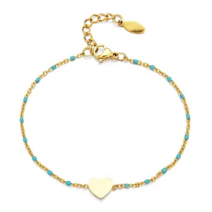 Detail shot of a minimalist gold stainless steel heart bracelet with turquoise enamel beads