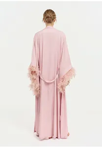 Vue arrière détaillée d'une élégante robe en satin rose avec garniture en plumes luxueuses