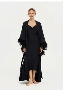 Peignoir élégant en satin noir pour femme avec bordure en plumes amovibles.