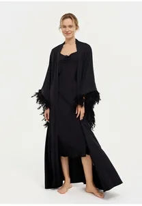 Élégant peignoir noir long avec des manches luxueuses ornées de plumes amovibles