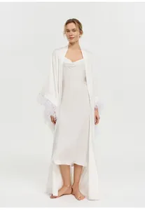 Peignoir de mariée blanc élégant avec plumes luxueuses aux manches et robe assortie.