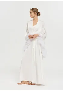 Vue détaillée d'un peignoir en soie blanche de luxe avec poignets en plumes élégants.
