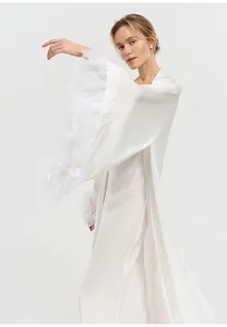 Détail du peignoir en satin blanc avec garniture en plumes sur les manches