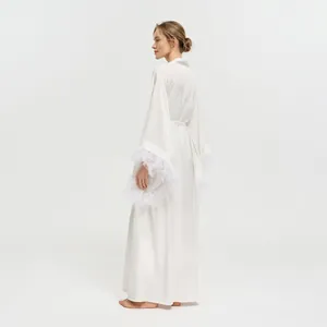 Élégant peignoir de mariée long blanc avec de luxueuses plumes au bout des manches