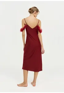 Vue arrière d'une luxueuse chemise de nuit en satin rouge avec bordure en plumes élégante