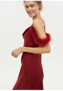 Détail d'une nuisette en satin rouge avec un col bénitier élégant et une bordure en plumes