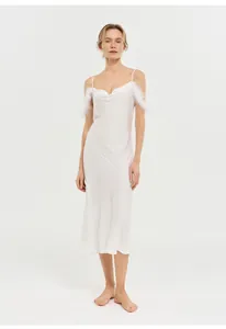 Vue détaillée d'une chemise de nuit blanche moulante à col bénitier et plumes.
