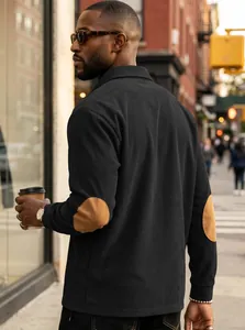 Close-up detailed view of black corduroy men's polo shirt featuring brown elbow patches