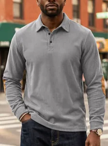 Detailed view of grey corduroy polo shirt featuring brown elbow patches and lapel collar