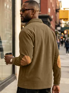Detailed street style view of men's olive corduroy polo sweatshirt with elbow patches