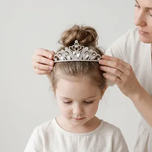 Couronne de princesse élégante en strass argentés placée sur la tête d'une fille
