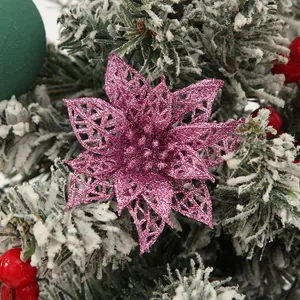 Detail view of a pink glitter poinsettia flower on a frosted Christmas tree branch