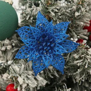 Detailed view of a blue glitter hollow Christmas flower on a snowy decorative tree