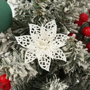 Decorative white hollow glitter poinsettia flower with red berries on snowy Christmas pine