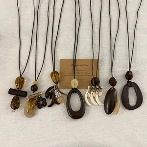 Macro view of handmade long necklaces with diverse wood and resin pendants in punk style