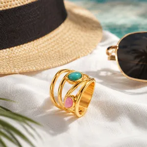 French style stainless steel multi-layer ring with turquoise and pink stones on a beach.