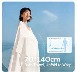 Large 70x140cm white waffle-weave compressed bath towel shown as a wrap-around bathrobe on a model