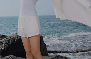White disposable compressed bath towel for travel held by a woman at the beach
