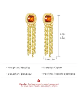 Detail view of long gold tassel earrings with amber gemstone and copper material specs