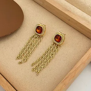 Detailed view of vintage court-style gold earrings with amber stones and tassels