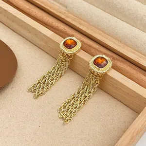 Detailed macro view of vintage palace style golden tassel earrings with orange gemstones