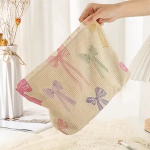 Large corduroy cosmetic bag featuring colorful bow prints and secure zipper closure