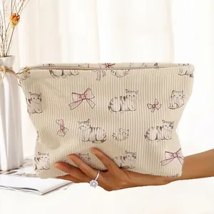 Detail of corduroy makeup bag with watercolor cat and pink bow prints