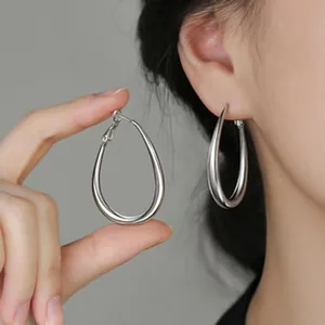 Detailed shot of elegant silver teardrop hoop earrings with a smooth polished finish