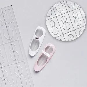 Close-up of elegant white and pink nail art designs created with hollow airbrush stencils