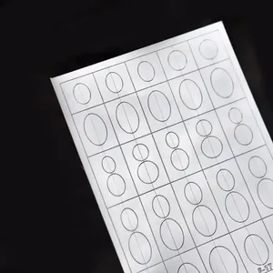 Detailed macro view of white Tomoni nail art stencil sheet with oval cutout patterns