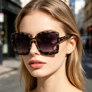 Modische Frau mit übergroßer Leoparden-Sonnenbrille und lila Verlaufsgläsern im Freien