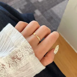 Détail d'une délicate bague ouverte en argent S925 doré avec motif cœur et micro-pavé